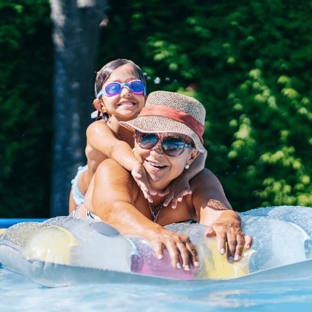 A woman enjoying a pool with her grandchildren 